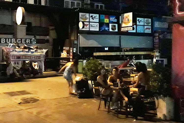 Fire thaier sitter og drikker ved et bord utenfor Tree Town i Pattaya. I bakgrunnen ses Kåres Partybar, som måtte stenge.