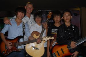 Frank Hagen overrekker gitarer til guttene på Baan Jing Jai