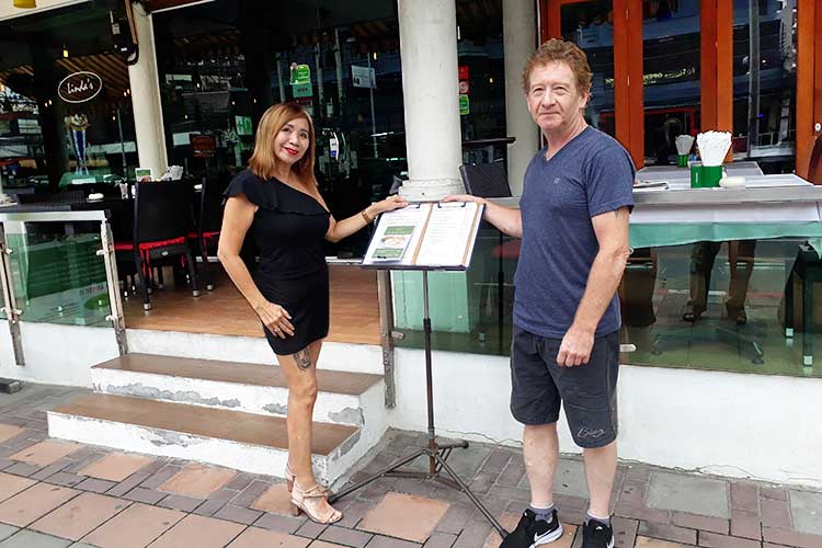 Hans Grumheten tar over for Linda Eiksund, her foran restauranten på vegen fra Pattaya ned til Jomtien Beach.